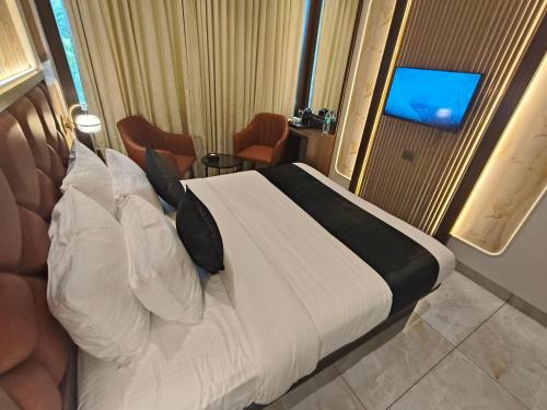 a bed in a hotel room with a television at Hotel Ocean Residency Thane West in Thane