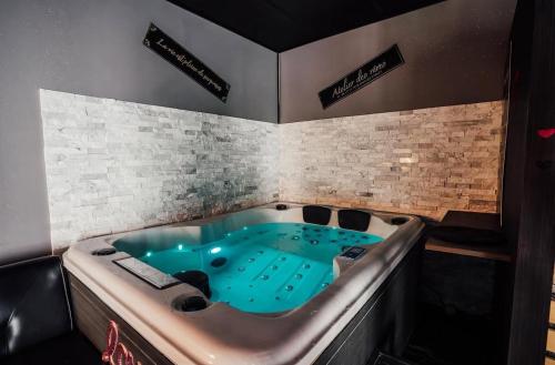 a jacuzzi tub in the middle of a room at Ô Saphir Spa - Maison N1 in Denain