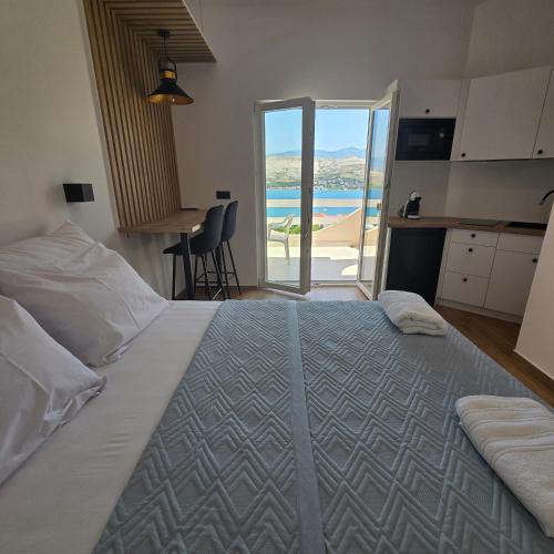 a bedroom with a bed with a view of the ocean at Sun Anna Apartments in Pag