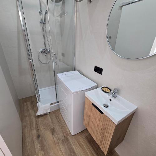a white bathroom with a shower and a sink at Sun Anna Apartments in Pag