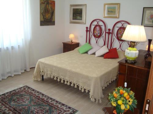 a bedroom with a bed with red and green pillows at La Sosta di Braccio in Macchie