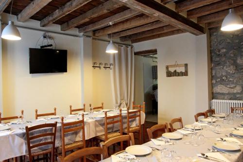 a dining room with tables and chairs and a television at Locanda Il Gigante in Collagna