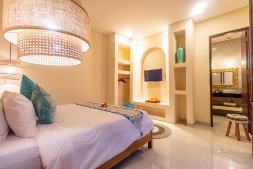 a bedroom with a bed and a chandelier at Villa Amaia Canggu in Kerobokan