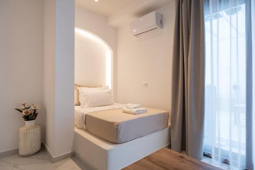 a small bedroom with two beds and a window at Meltemi Marmaras in Neos Marmaras