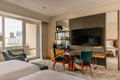 a hotel room with a bed and a desk with a television at Four Seasons Hotel Ritz Lisbon in Lisbon