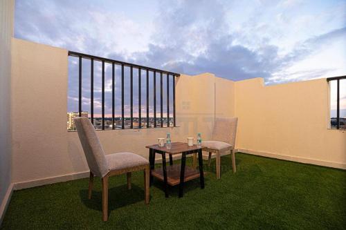 a room with a table and two chairs and a window at لميك للشقق المخدومة in Al Bukayriyah