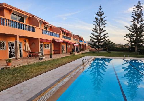 a resort with a swimming pool in front of a building at L'oasis d'Agadir - Agadir's hidden Oasis in Agadir