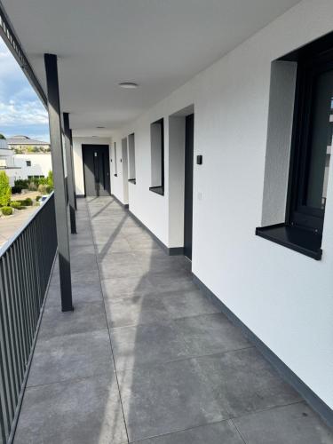 a hallway of a building with white walls and a sidewalk at Be Grand Apartments Rust in Rust