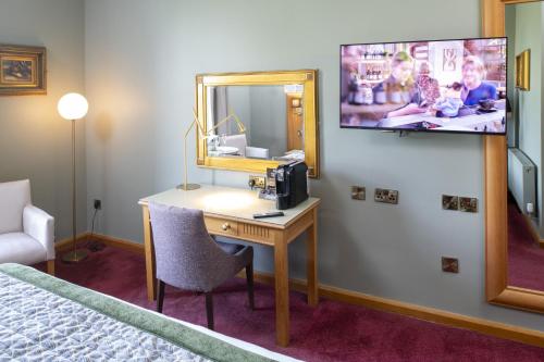 a room with a desk and a mirror and a bed at Roganstown Hotel & Country Club in Swords