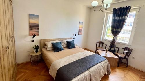 ein Schlafzimmer mit einem Bett mit blauen Kissen in der Unterkunft Tortosa Blue in Split