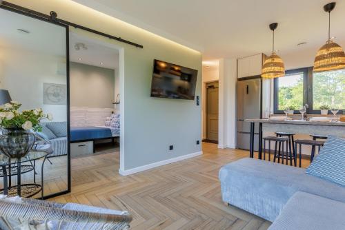 a living room and kitchen with a couch and a table at Solo na wyspie, blisko morza Sobieszewo in Gdańsk