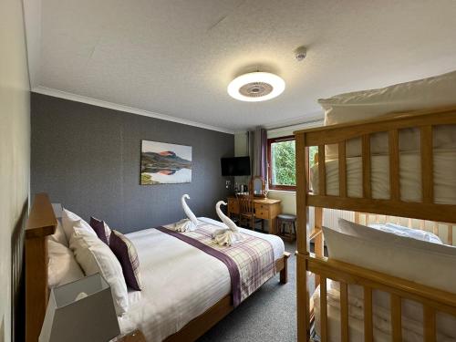 a bedroom with two bunk beds and a cat on a bed at Guisachan Guesthouse in Fort William