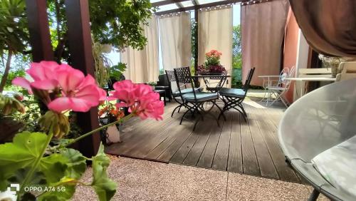 a screened in porch with chairs and tables and flowers at B&B Terre Di Bea in Pederobba