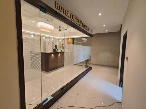 a man standing in front of a store window at Hotel Ocean Residency Thane West in Thane