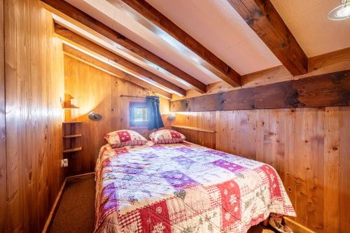 a bedroom with a bed in a room with wooden walls at Appartement 12 - Les Aravis in Crest-Voland