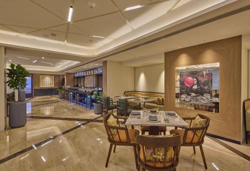 a restaurant with tables and chairs in a lobby at ICONIQA Hotel Mumbai International Airport in Mumbai