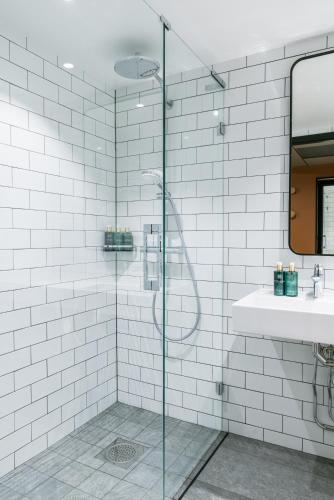 a bathroom with a glass shower and a sink at Clarion Hotel Winn in Gävle
