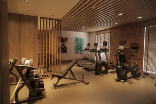 a gym with several treadmills and machines in a room at Radisson Resort Hatgad Saputara in Saputara
