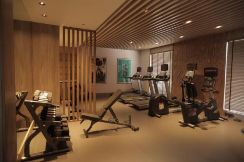 a gym with several treadmills and machines in a room at Radisson Resort Hatgad Saputara in Saputara