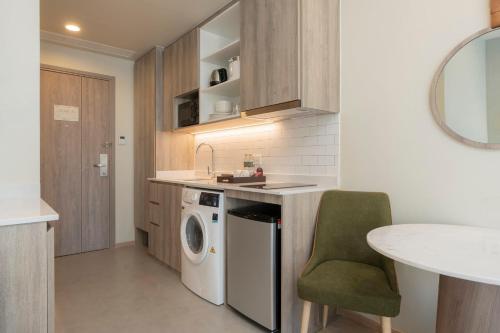a kitchen with a sink and a washing machine at Staybridge Suites Bangkok Sukhumvit by IHG in Bangkok