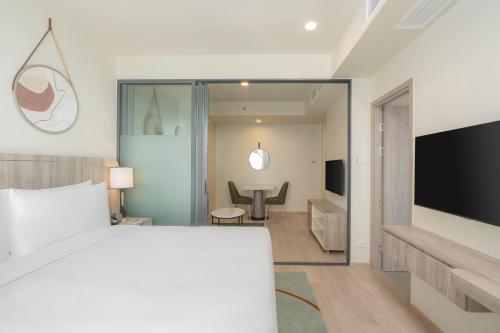a hotel room with a bed and a television at Staybridge Suites Bangkok Sukhumvit by IHG in Bangkok