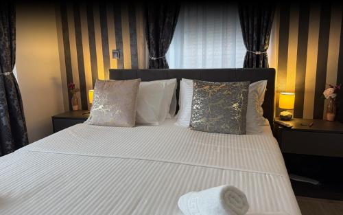 a bedroom with a bed with white sheets and pillows at Alsago Lux in Sesvete