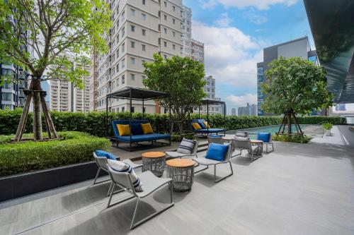a patio with chairs and tables in a city at Staybridge Suites Bangkok Sukhumvit by IHG in Bangkok