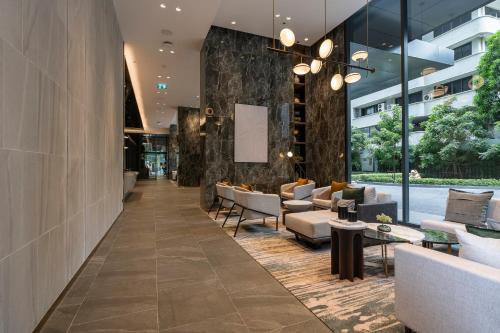 a lobby of a building with couches and chairs at Staybridge Suites Bangkok Sukhumvit by IHG in Bangkok