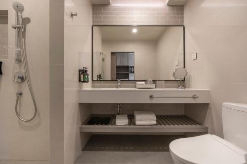 a bathroom with a sink and a toilet and a mirror at Staybridge Suites Bangkok Sukhumvit by IHG in Bangkok