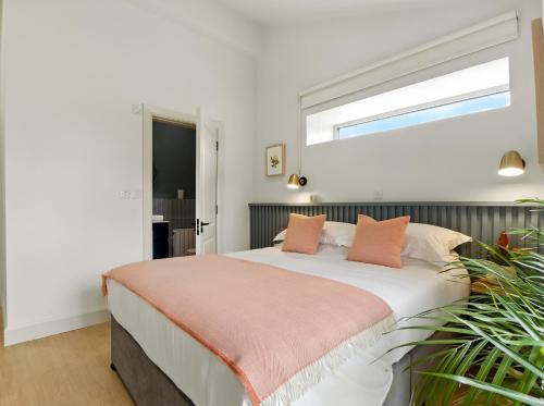 a bedroom with a large bed with orange pillows at The Warehouse, Clifden in Clifden