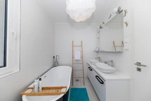 a white bathroom with a sink and a mirror at Alba Family Home in Zadar