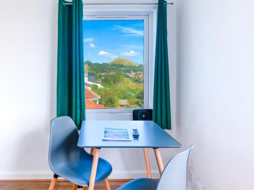 a blue table and chairs in front of a window at Glastonbury Studio - Tor View - Sleeps 2 in Glastonbury