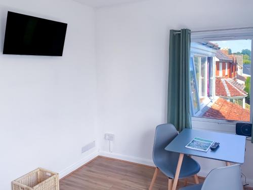 a small room with a table and a window at Glastonbury Studio - Tor View - Sleeps 2 in Glastonbury