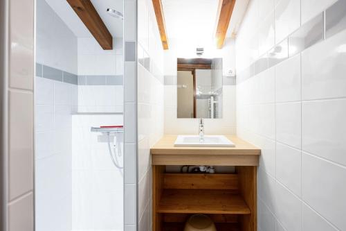une salle de bain avec un lavabo et un miroir dans l'établissement Studio 16 - Le Lagopede, à Cohennoz