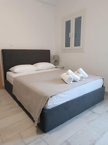 a bedroom with a large bed with two towels on it at Klimis apartments in Sifnos