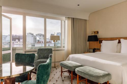 a hotel room with a bed and a table and chairs at Four Seasons Hotel Ritz Lisbon in Lisbon