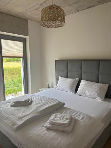 a bedroom with a large bed with two towels on it at Domus Cobile in Kobylí
