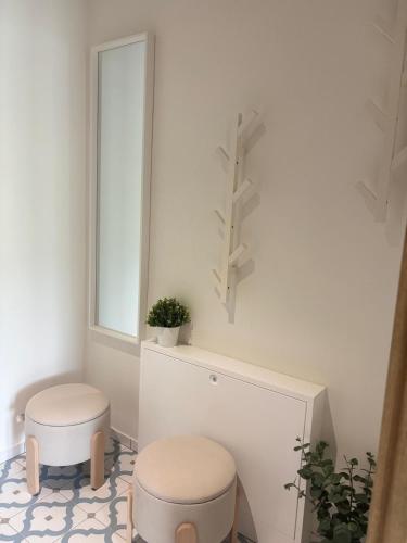 a white bathroom with two stools and a window at Domus Cobile in Kobylí