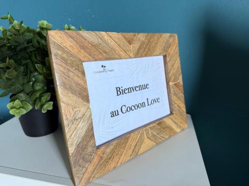 a sign on a table next to a potted plant at Cocoon Love avec piscine privative in Saint-Louis