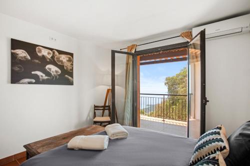 une chambre avec un lit et une porte coulissante en verre dans l'établissement Grande Villa 750 m2 Le Mas des chênes, à Bormes-les-Mimosas