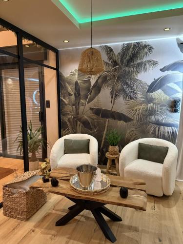a living room with a table and two chairs at L'Apogée in Noyal-Pontivy