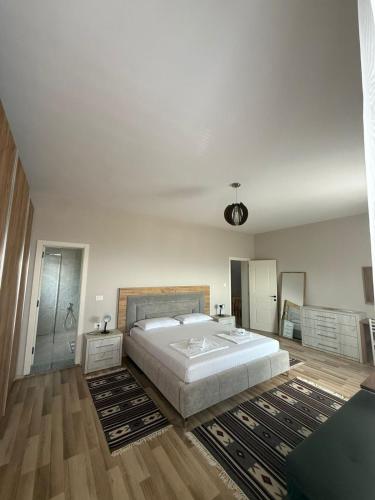 a large white bedroom with a large bed and a rug at Villa Duka in Krujë