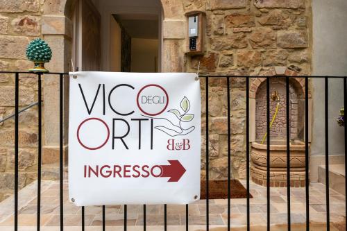 a sign on a fence in front of a building at Vico degli Orti in Mistretta