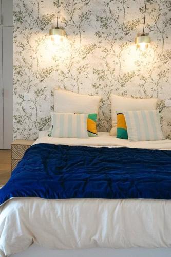 une chambre avec un grand lit avec des draps bleus dans l'établissement Loft vue mer - Angoulins - Villa Oasis, à Angoulins-sur-Mer