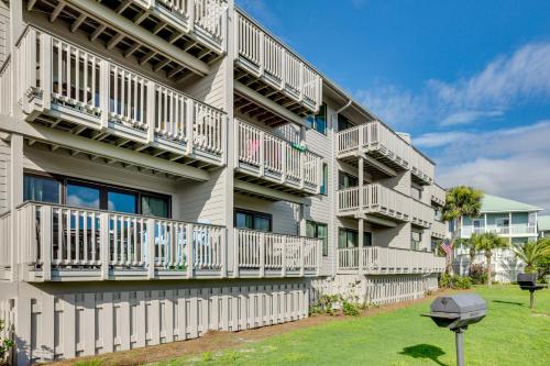 a white apartment building with balconies and a yard at St Helena Island Condo - half Mi to Beach in Oceanmarsh Subdivision