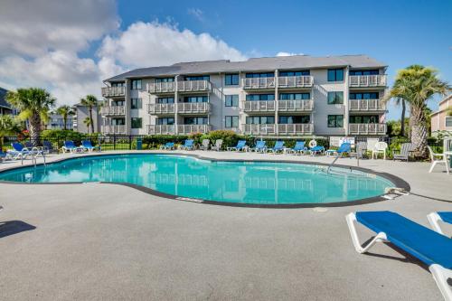 a swimming pool in front of a large apartment building at St Helena Island Condo - half Mi to Beach in Oceanmarsh Subdivision