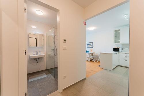 a white bathroom with a sink and a shower at Flex SelfCheckIns 149 - Zagreb - Bedroom - Garage - Loggia in Zagreb