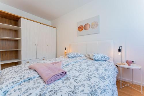 a bedroom with a bed with a blue and white blanket at Flex SelfCheckIns 149 - Zagreb - Bedroom - Garage - Loggia in Zagreb