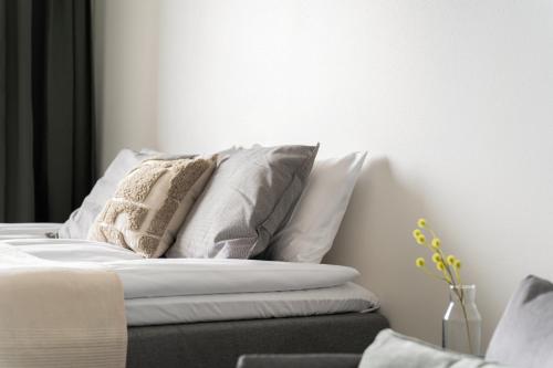 a white bed with pillows on top of it at Wallesmanni - Nokia Arena prime location apartments by Come in! in Tampere