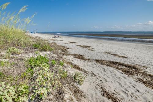 a sandy beach with people sitting on the beach at St Helena Island Condo - half Mi to Beach in Oceanmarsh Subdivision